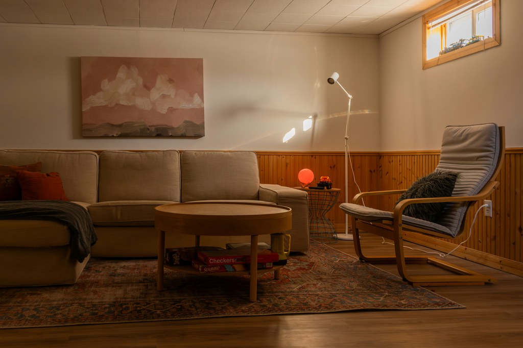 L-shaped sofa paired with an accent chair and round coffee table in a cozy basement living room.