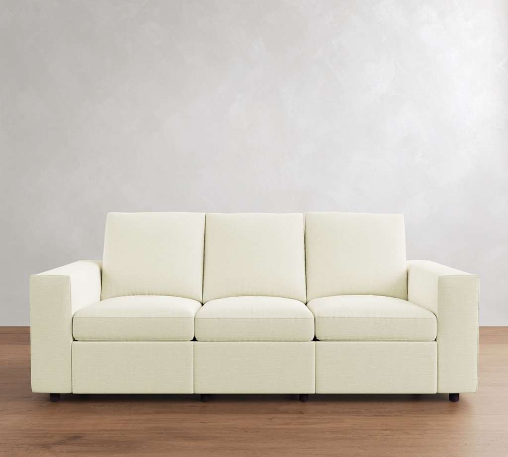 Cream three-seat reclining sofa against a light gray wall on a wood floor.