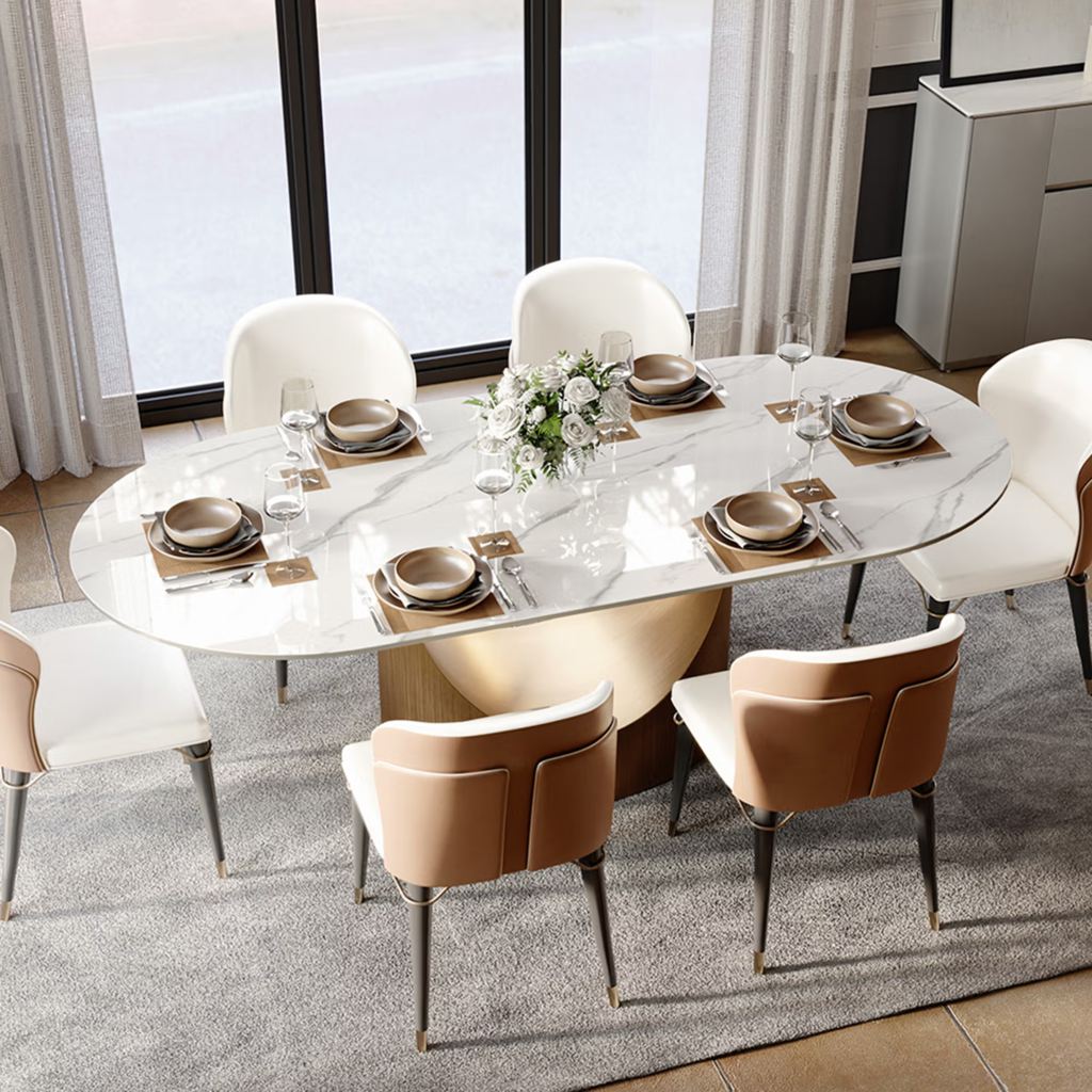 Oval sintered stone dining table with rounded edges and a central pedestal base set for six in a modern dining room.