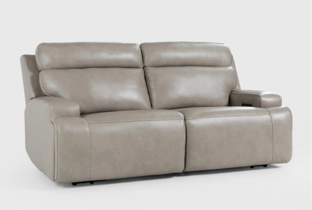 Light gray two-seat power reclining loveseat with padded headrests and wide armrests on a plain studio background.
