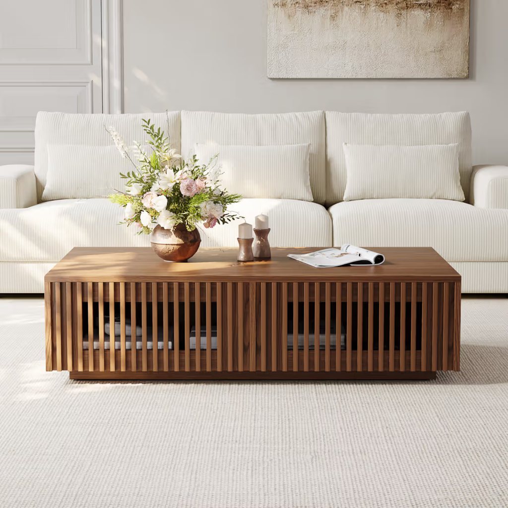 Rectangular walnut slatted coffee table with open storage in front of a white sofa.