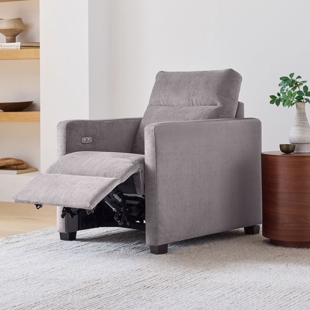 Gray fabric power recliner with an extended footrest in a minimalist living room.