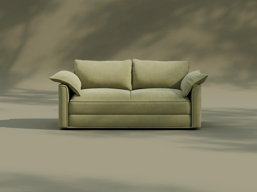 Light green two-seat sofa with loose back cushions against a neutral backdrop
