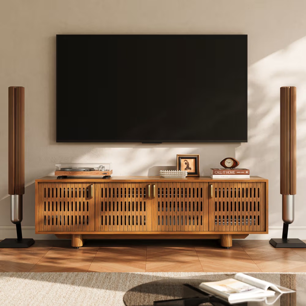 Walnut slatted TV stand beneath a wall-mounted TV with floor speakers in a modern living room.