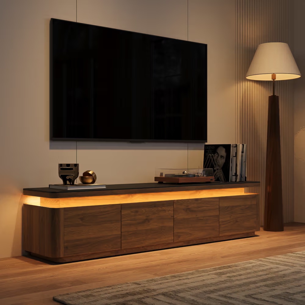 Turntable and vinyl records on a low walnut media console with ambient lighting beneath a wall-mounted TV.