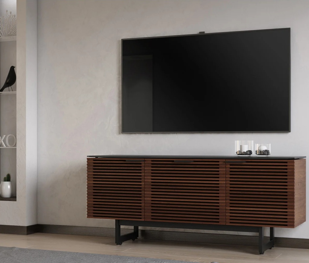 Walnut louvered media console beneath a wall-mounted TV in a modern living room.