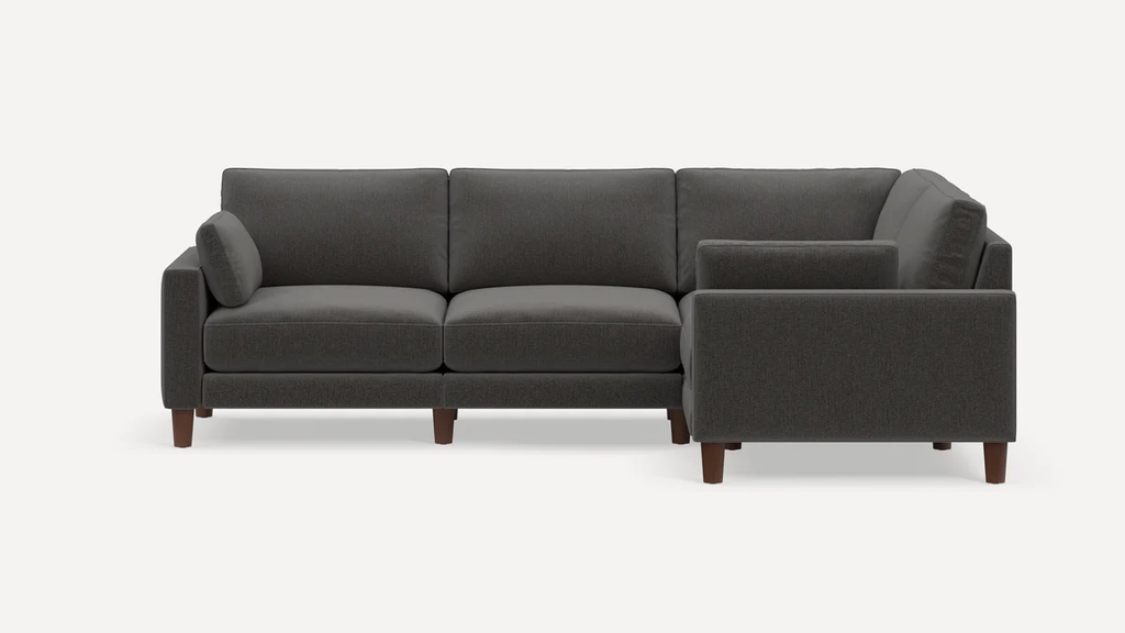 Dark gray L-shaped sectional sofa with wood legs on a white background.