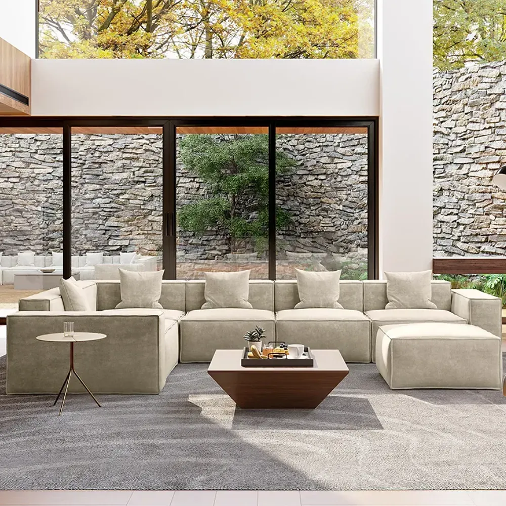 Large modular sectional sofa with chaise in a spacious modern living room with floor-to-ceiling windows.