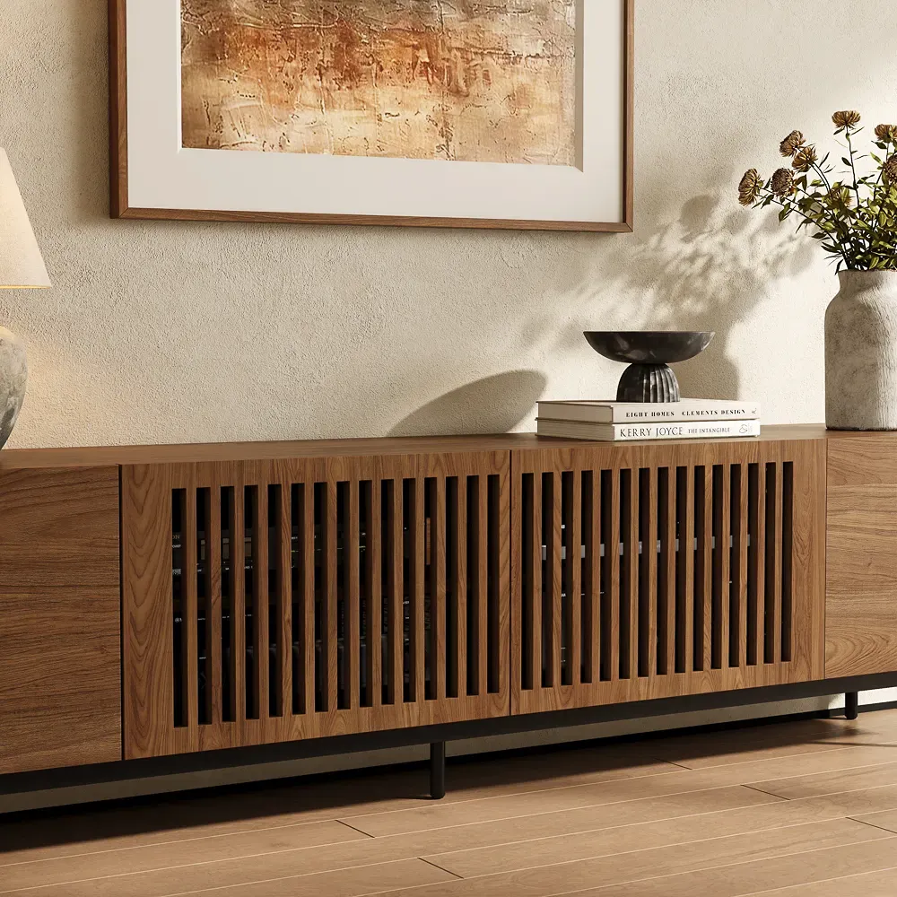 Walnut slatted media console with ventilated doors for AV equipment in a wall-mounted TV setup.