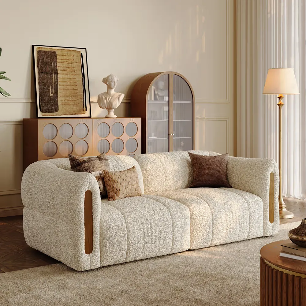Cream organic modern bouclé sofa with curved arms and wood accents in a neutral living room.