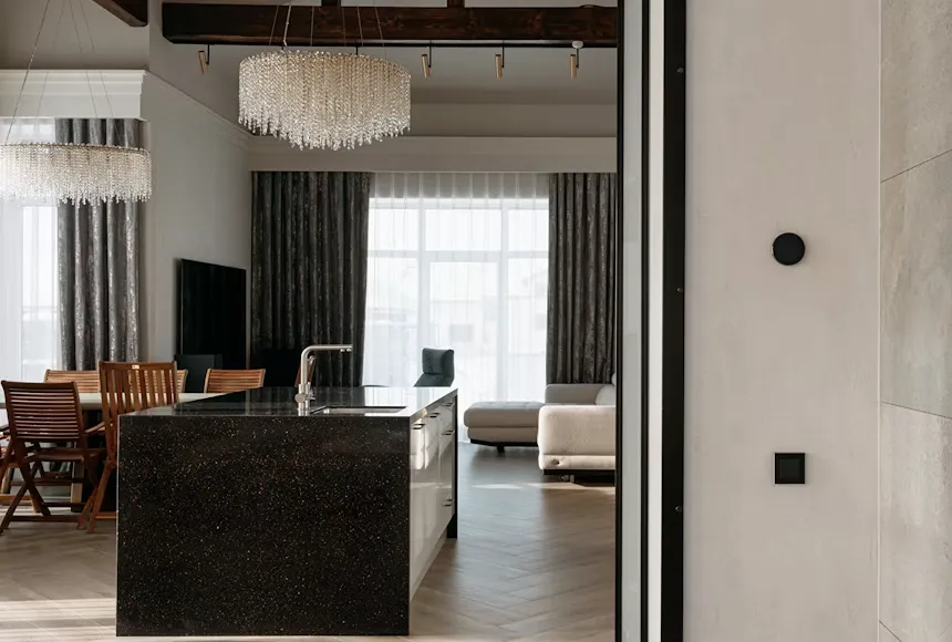 Open-plan living and dining area with dark cabinetry, wood furniture, and large windows