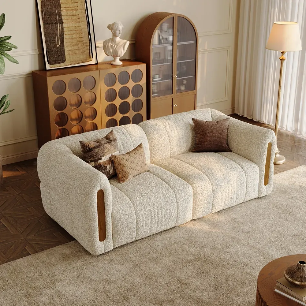 Low-profile cream bouclé sofa with rounded arms and wood accents in a warm modern interior.