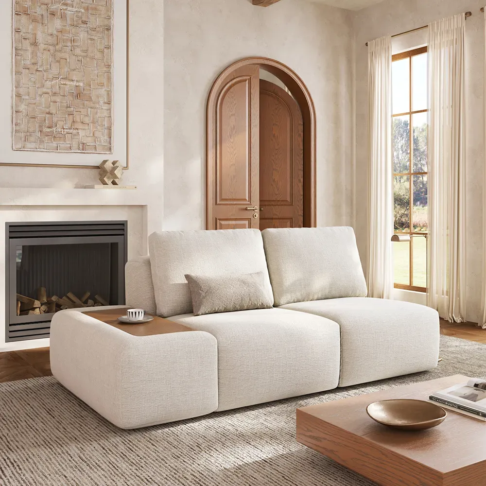 White modular two-seat sofa with a built-in wood side table beside a fireplace in a bright living room.