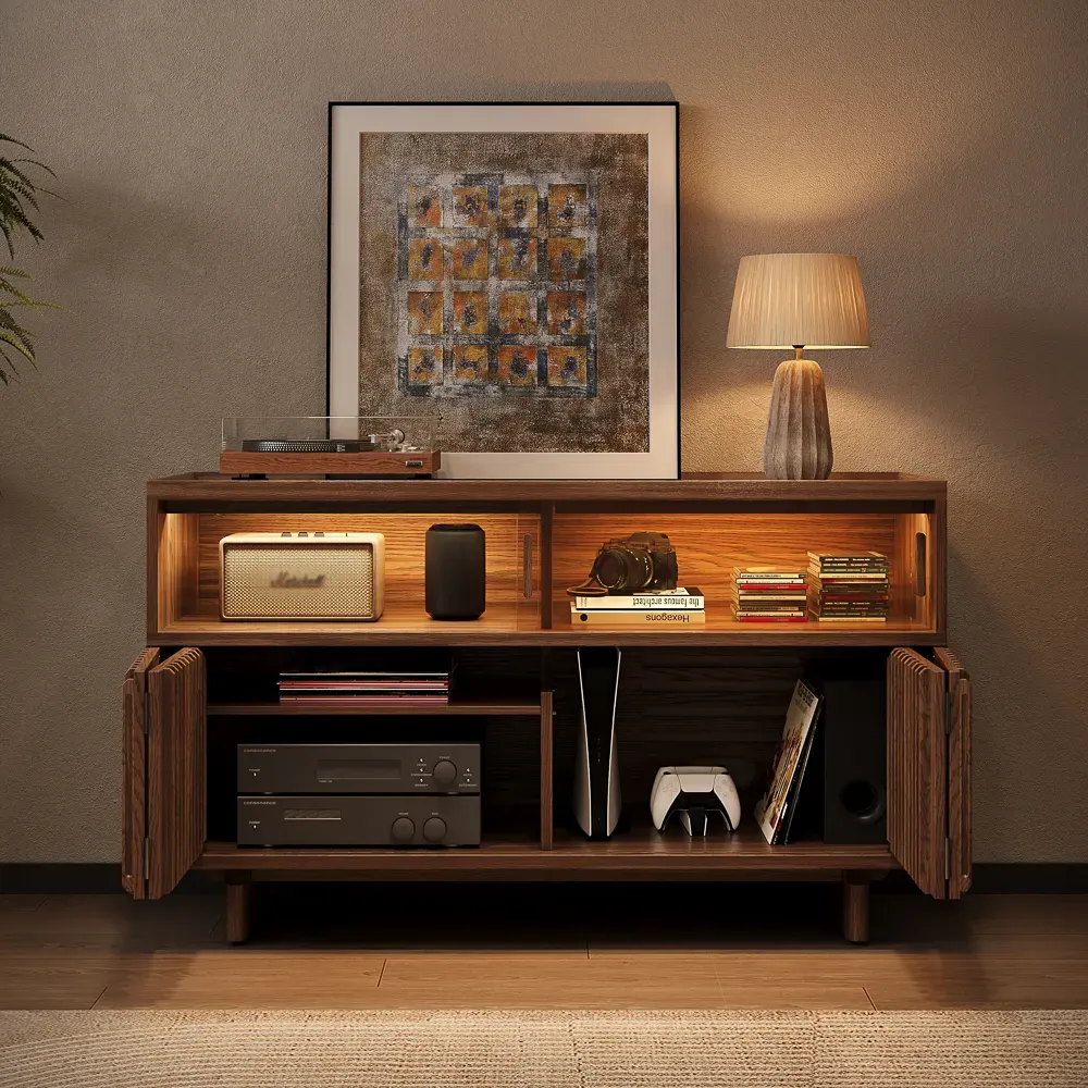 Wood record player stand with vinyl storage, audio components, speakers, and gaming console in a warm living room.