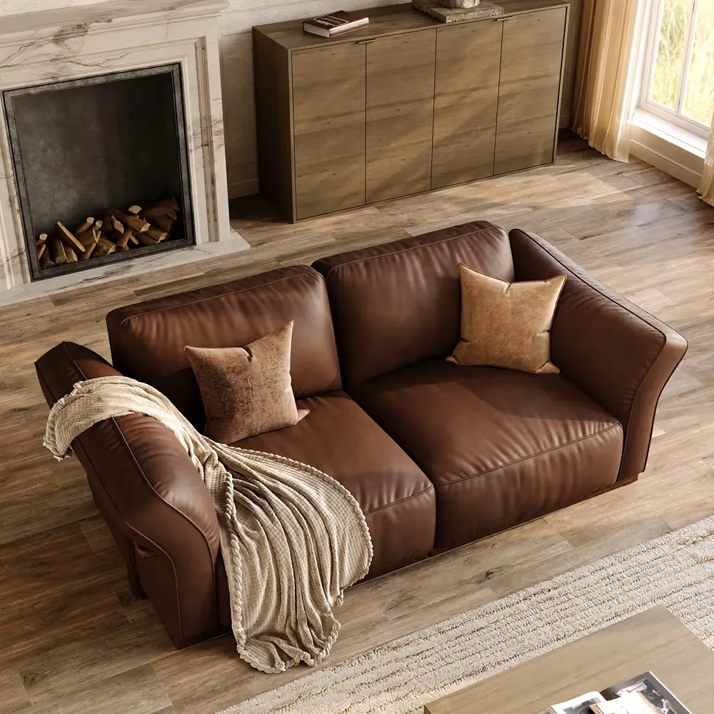 Dark brown leather sofa with textured neutral throw and pillows in a warm living room with light wood flooring and a cream rug