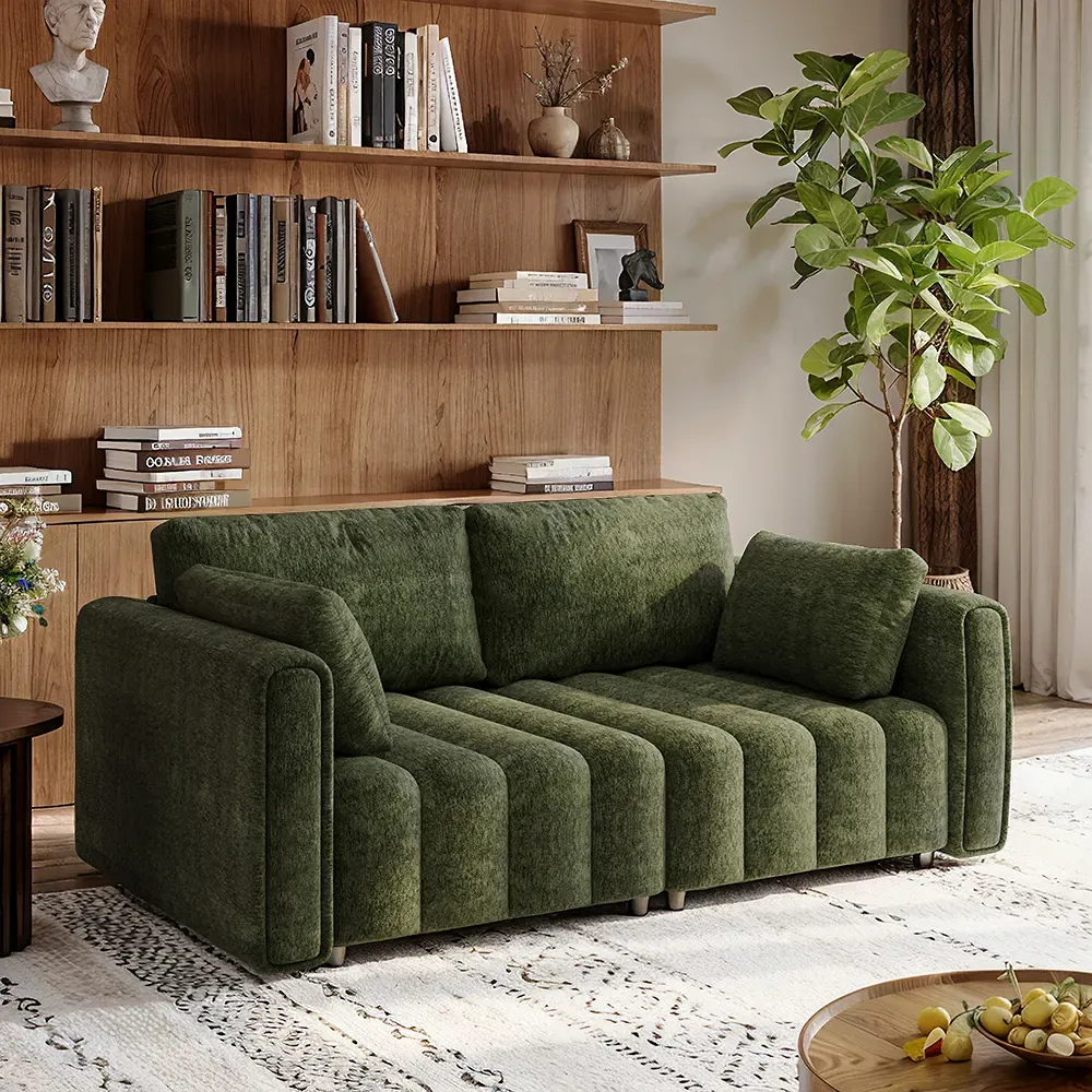 Green chenille tufted sofa with loose cushions in a cozy living room.