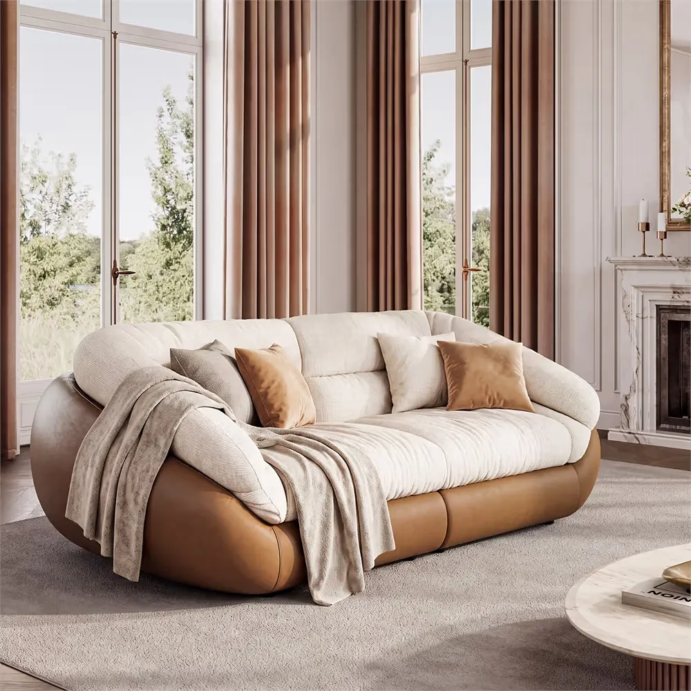 Organic modern sofa with cream upholstery and a tan base in a bright living room.
