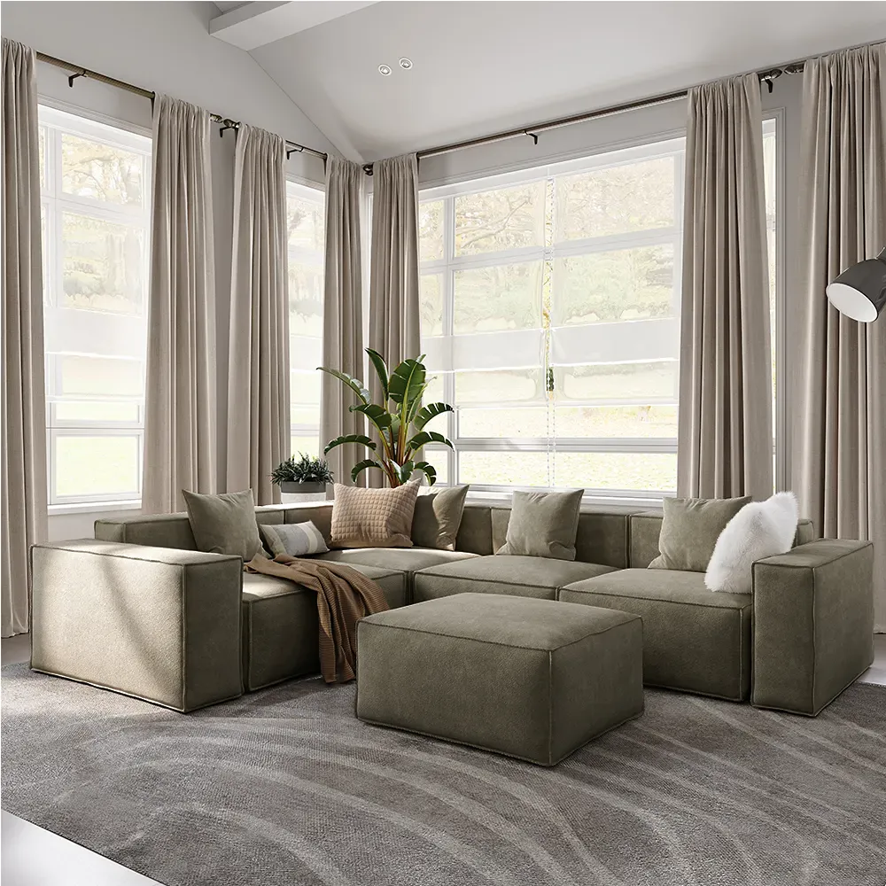 Green modular sectional sofa with ottoman in a sunlit living room with large windows.