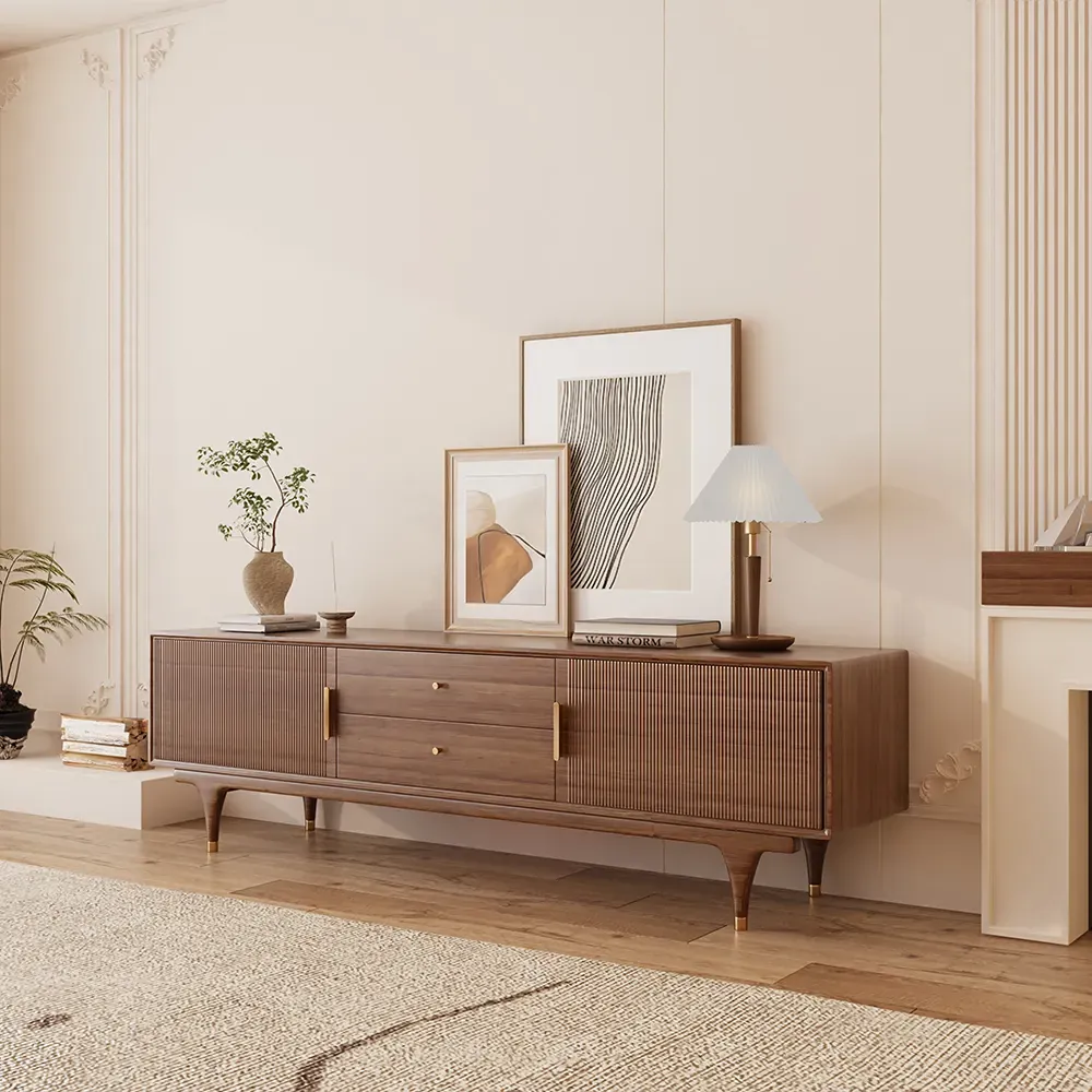Walnut TV stand with fluted sliding doors, center drawers, and raised legs in a modern living room.