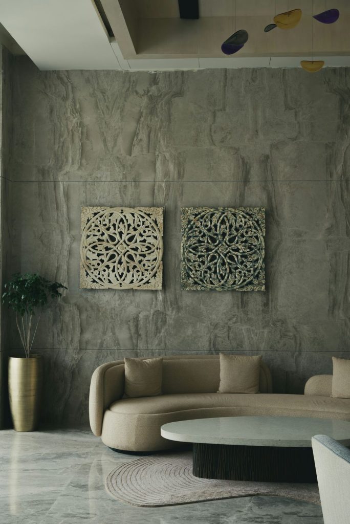 Curved beige sofa paired with a large oval coffee table in a contemporary living room.