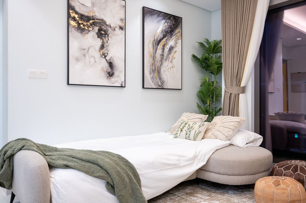 Fully extended sofa bed with white bedding in a modern multipurpose room