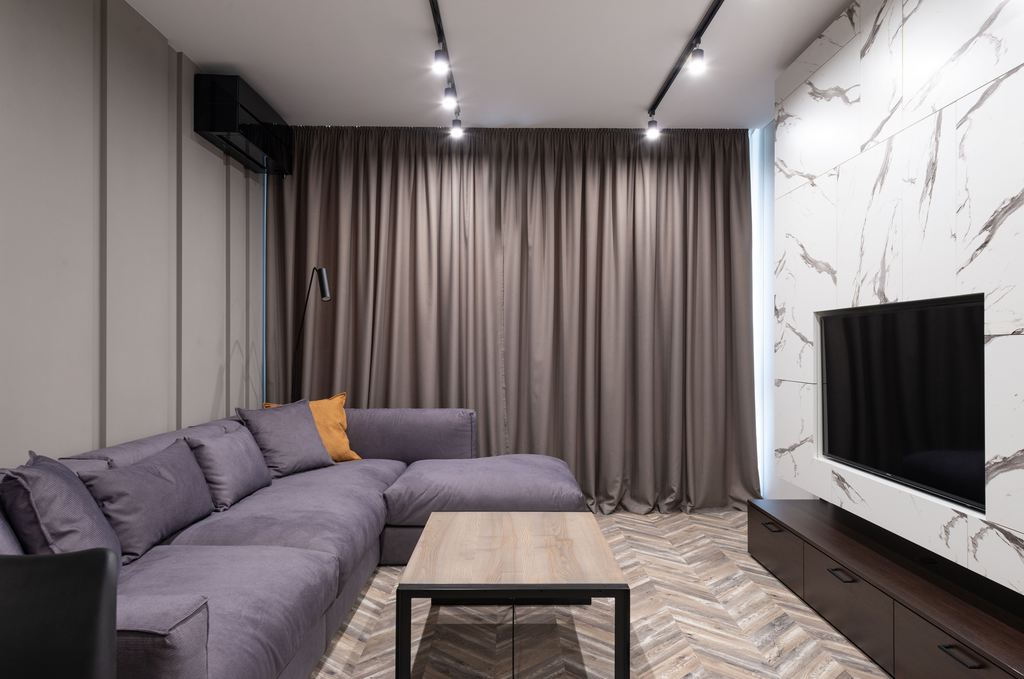 Gray sectional sofa with chaise in a modern living room facing a wall-mounted TV.