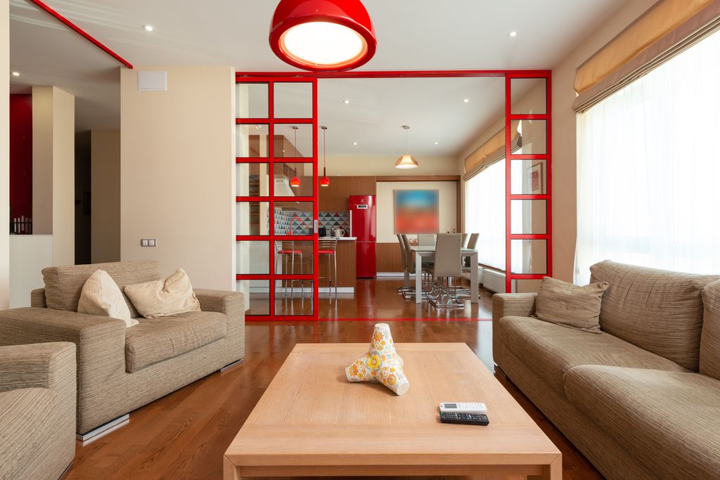 Shared apartment living room with two brown sofas, a central coffee table, and an open dining area.