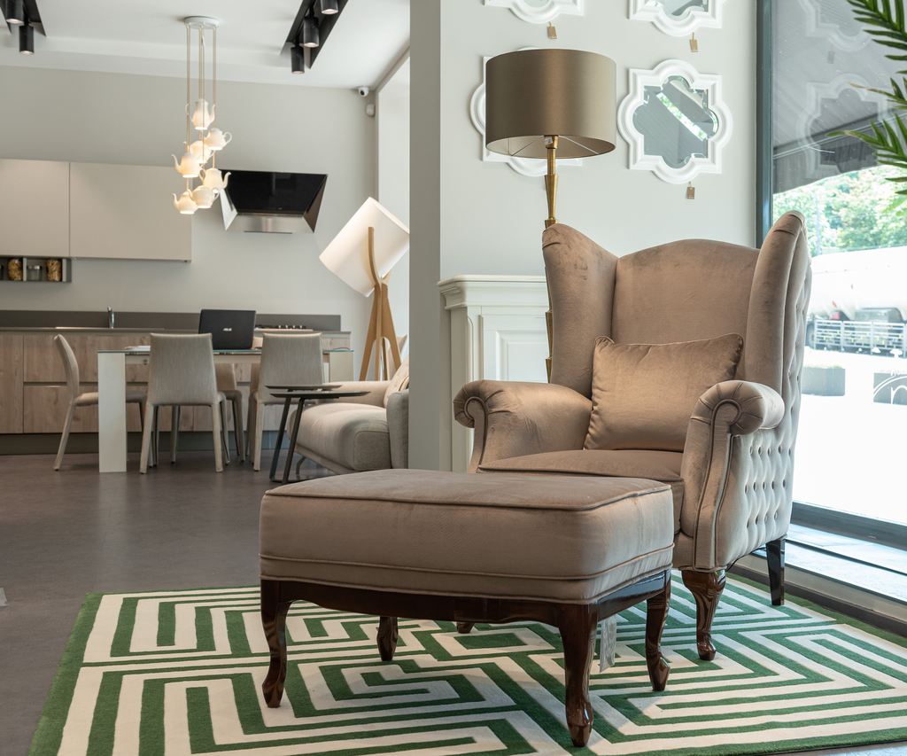 Upholstered wingback chair with matching ottoman in a modern living room.