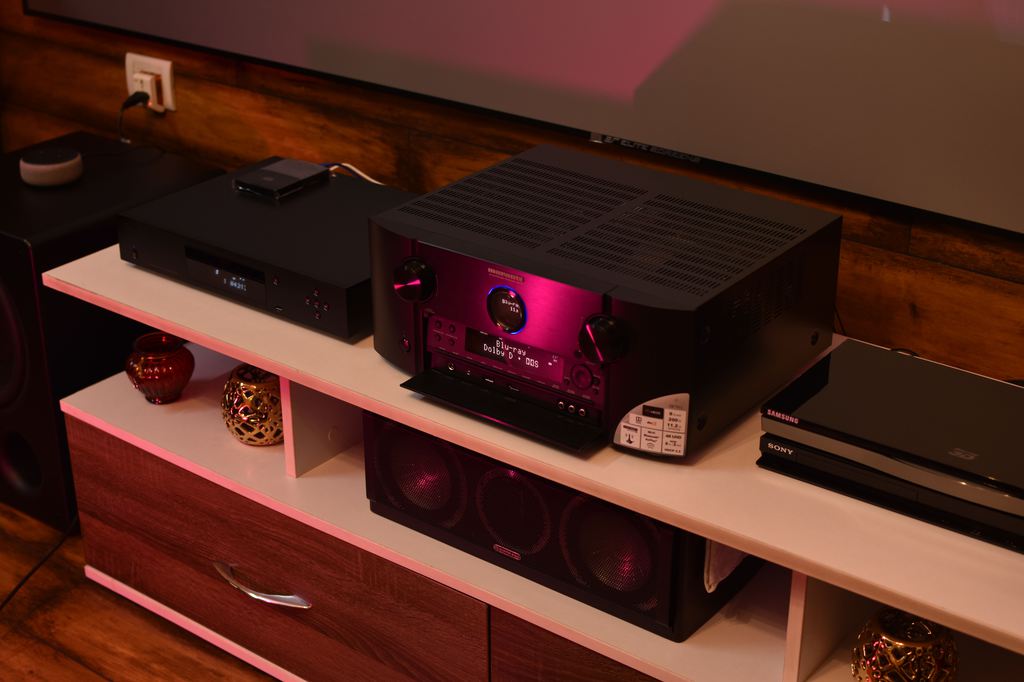 AV receiver and home theater components arranged on an open media console.