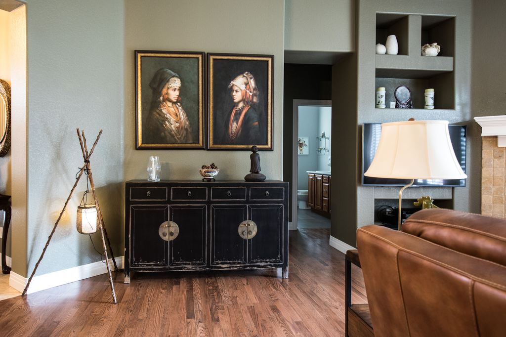 Heavy cabinet and leather sofa placed on hardwood flooring in a furnished living room.