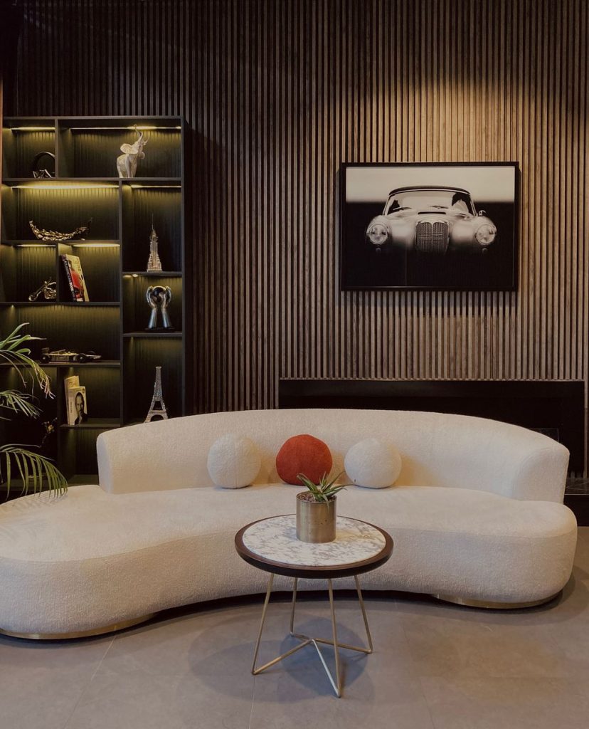 Curved white sofa paired with a small round marble coffee table in a modern living room.