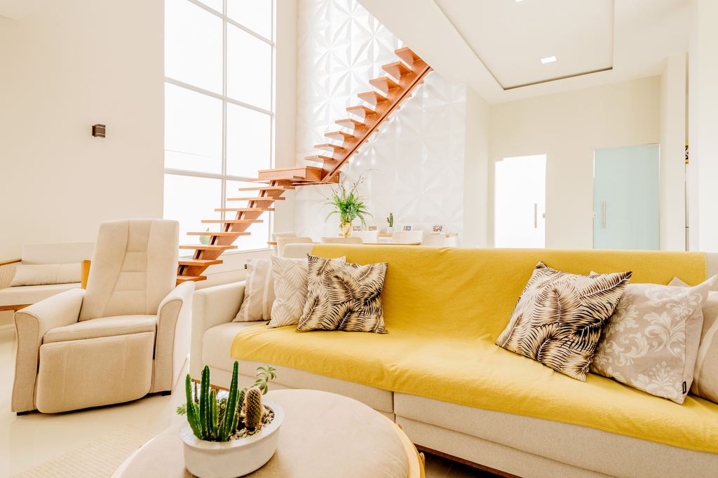 Beige power recliner beside a yellow sofa in a bright modern living room.