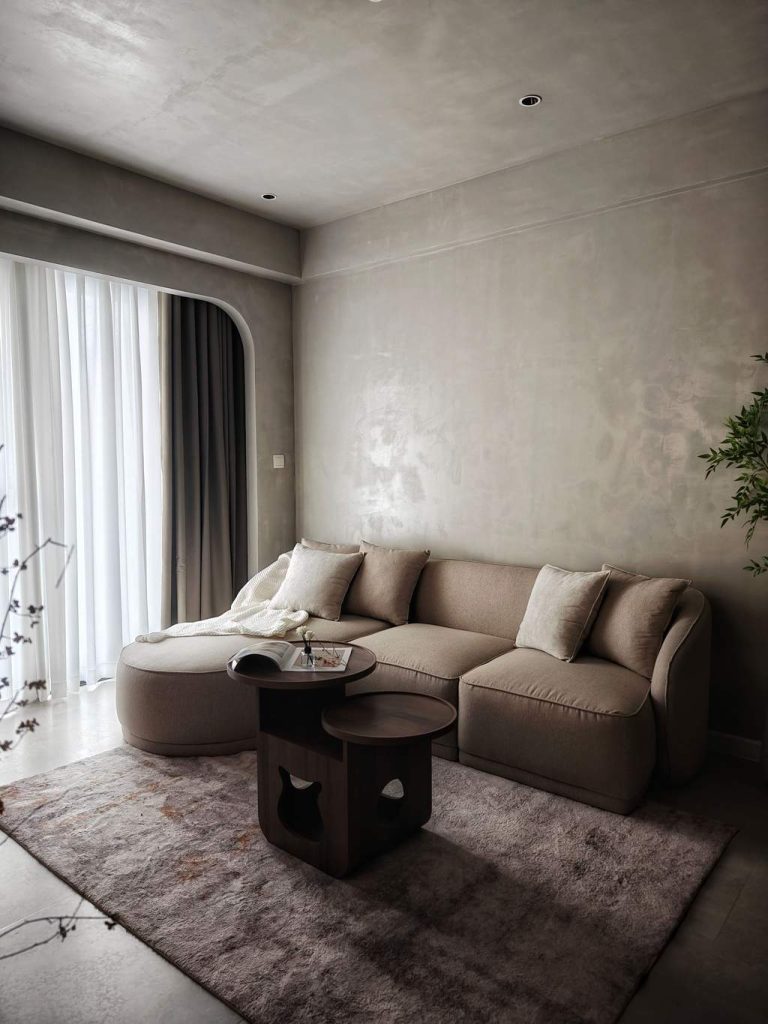 Beige modular sectional sofa on an area rug in a modern neutral living room