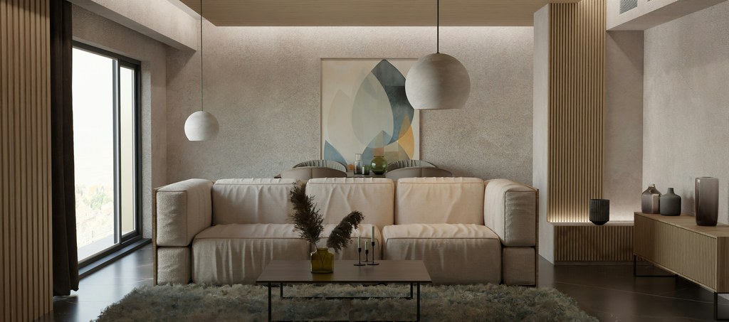 Modern neutral living room with a large cream sofa, low coffee table, pendant lights, and warm wood accents.