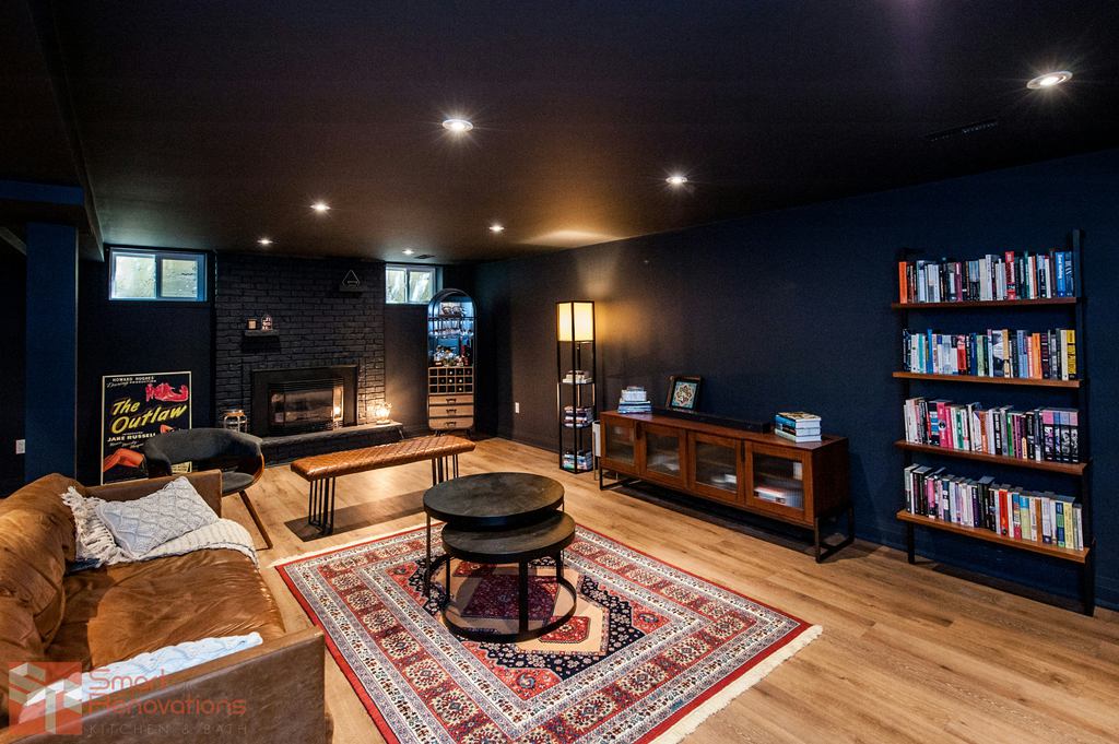 Cozy dark reading room with a brown leather sofa, bookshelves, fireplace, and layered lighting.