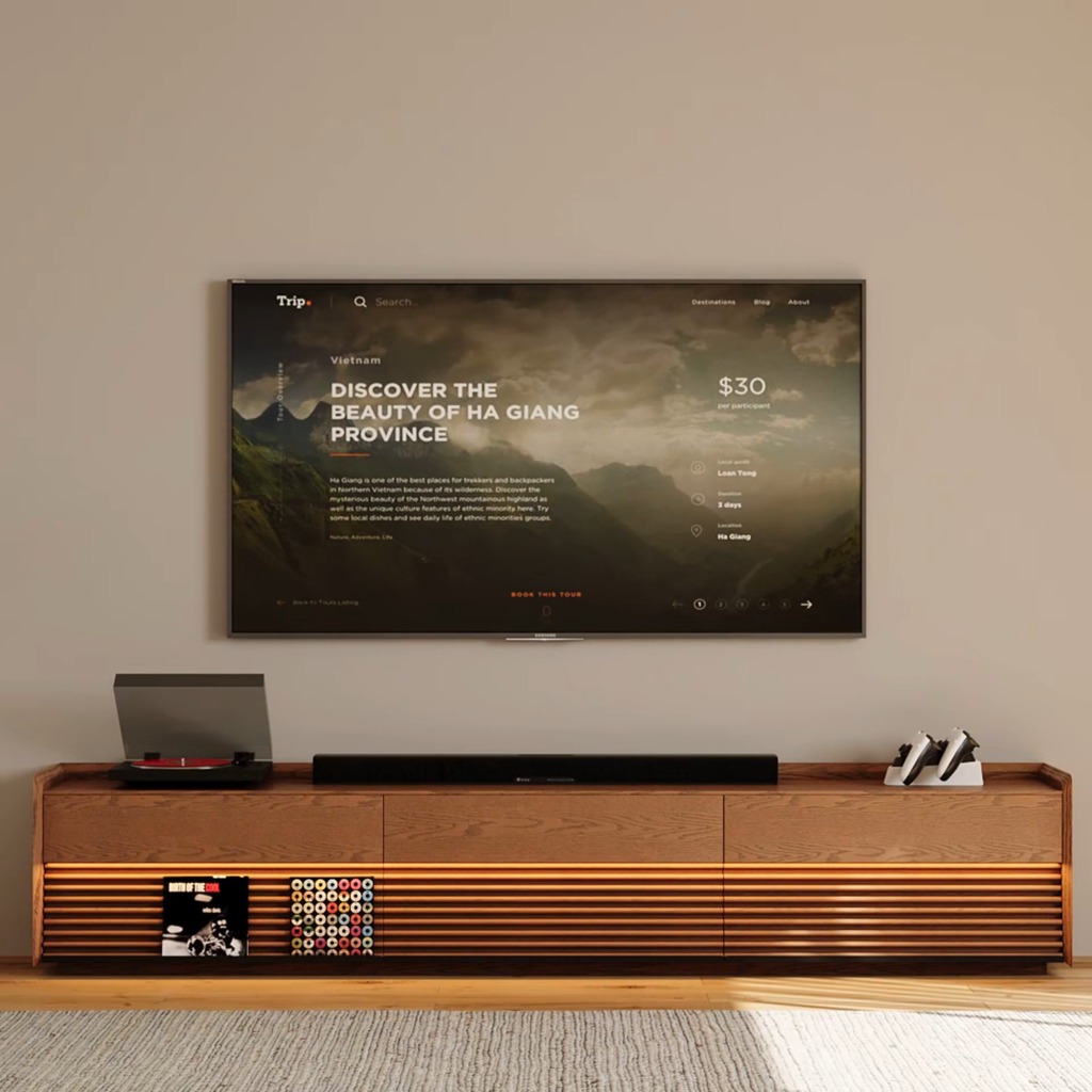 Modern living room media setup with a wall-mounted TV, wooden TV stand with LED lighting, soundbar, turntable, gaming controllers, and vinyl record storage.