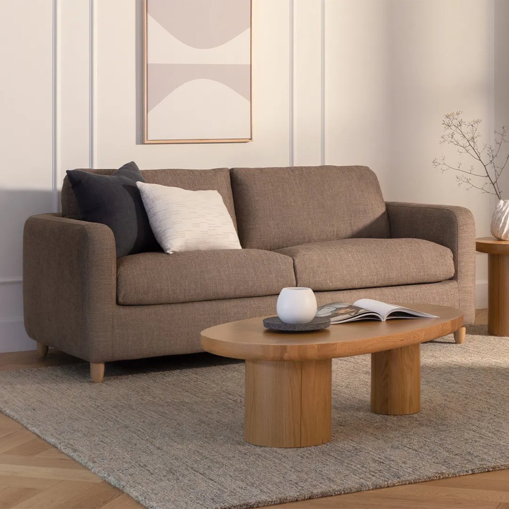 Brown upholstered sofa with deep seat cushions in a warm modern living room.