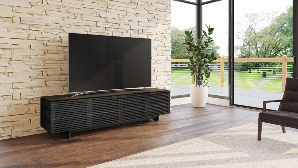 Black slatted media console with a large TV in a bright modern living room with floor-to-ceiling windows.