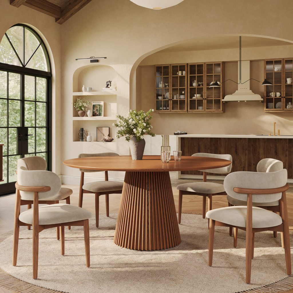 Modern Mediterranean dining room with a round walnut table, cream upholstered chairs, arched openings, warm plaster walls, and natural wood cabinetry.
