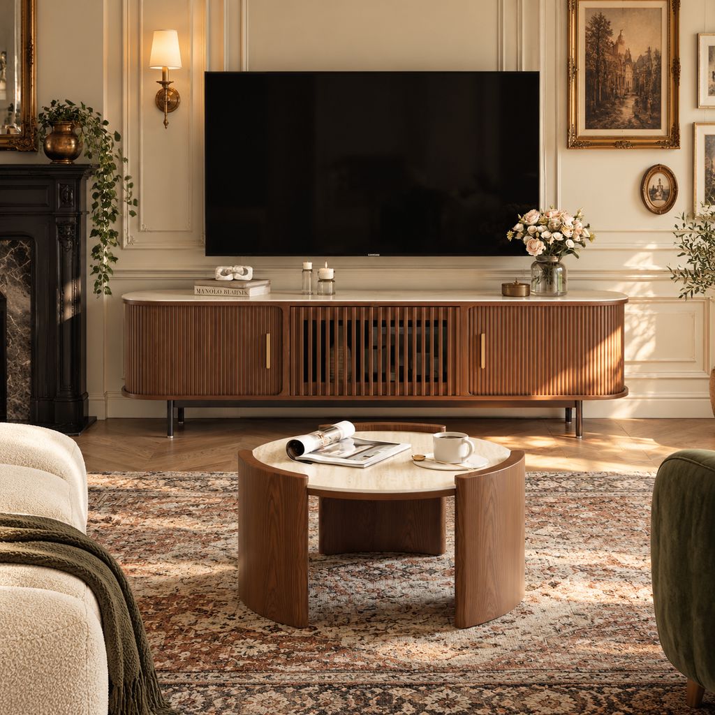 Modern Victorian living room with a walnut media console, wall-mounted TV, ornate molding, vintage artwork, patterned rug, and warm wood accents.