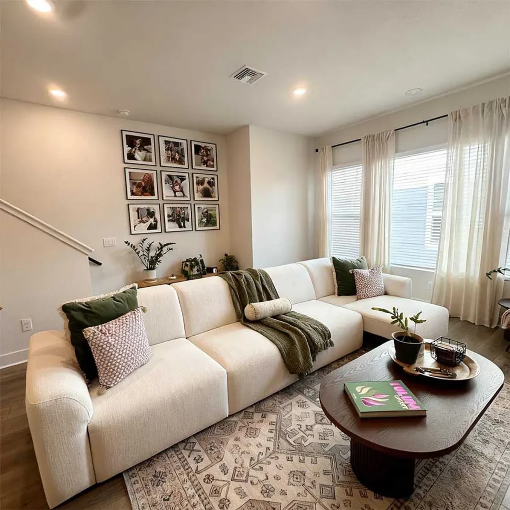 White power sofa bed in a modern living room with cozy pillows and coffee table