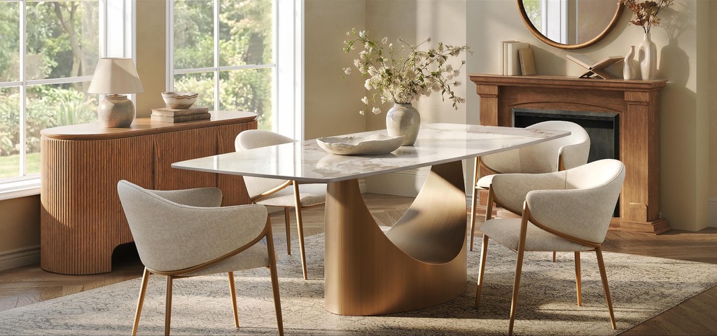 Rectangular marble dining table with upholstered chairs near large windows in a warm modern dining room.