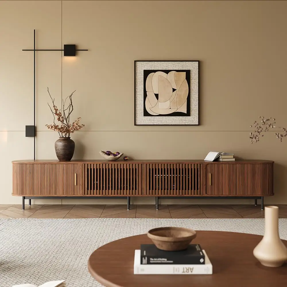 Walnut tambour-door TV stand with slatted cabinet fronts in a warm neutral living room.