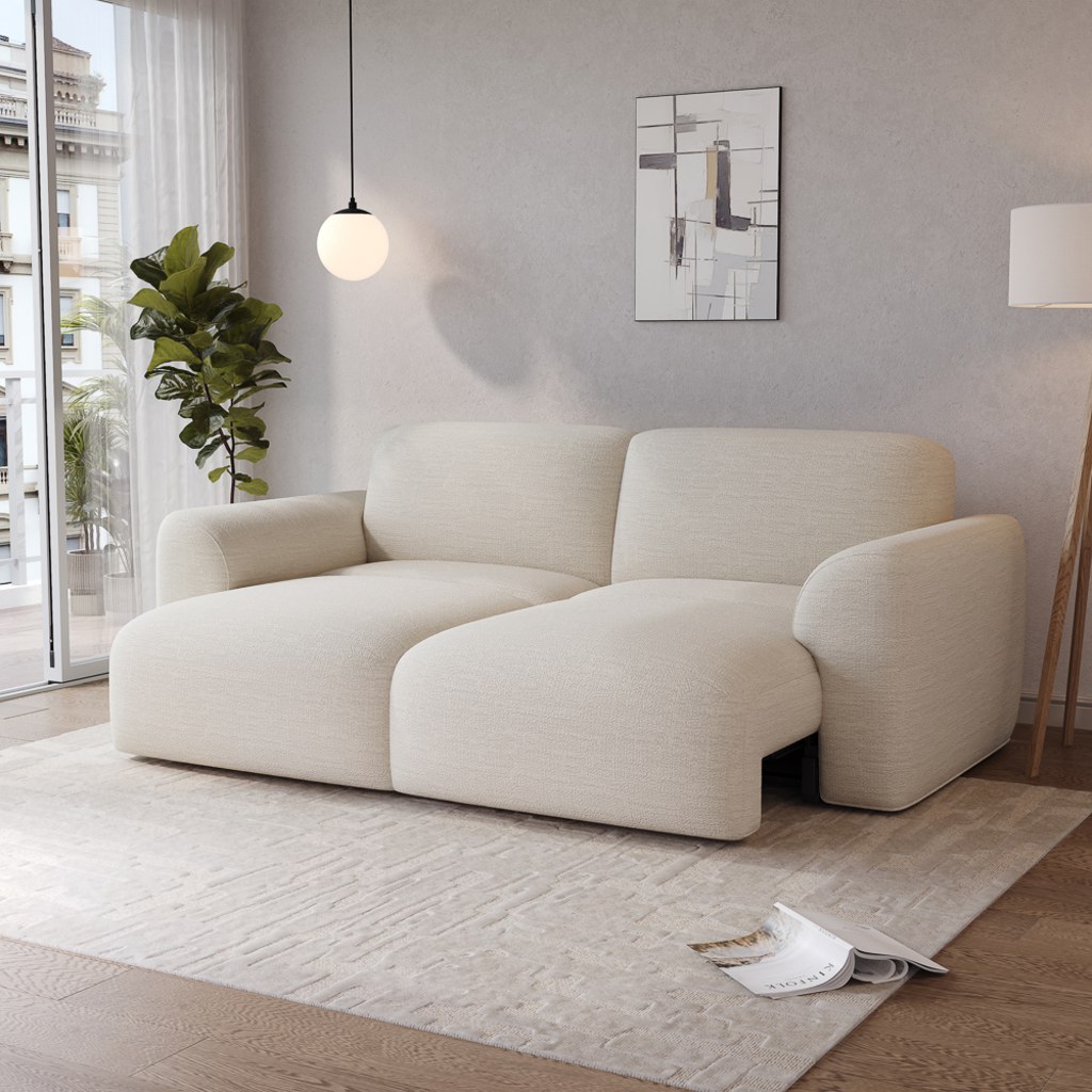 Cream modular sectional sofa bed with deep cushions and curved arms in a modern apartment living room with natural light, rug, plant, and minimalist decor.