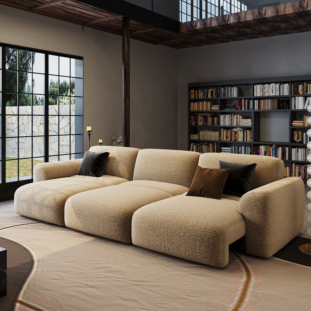 Cream modular sectional sofa bed in a modern living room with a bookshelf and large windows