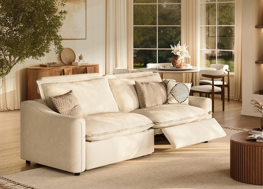 Cream high-arm power reclining sofa with plush cushions in a bright modern living and dining space.