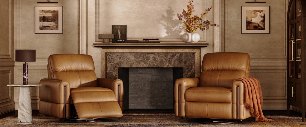 Two tan leather recliners positioned on a patterned rug in front of a marble fireplace.