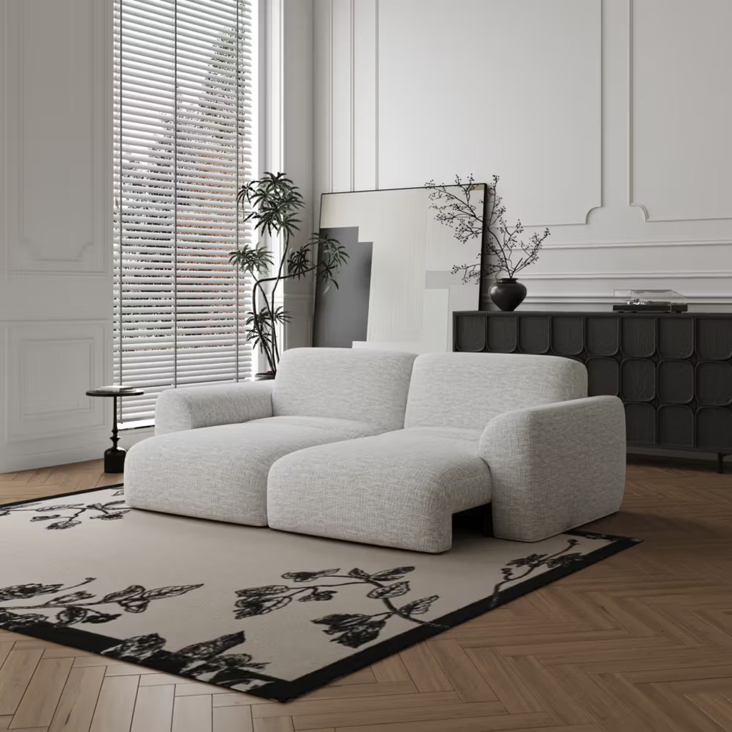Light gray sofa in a modern living room with warm wood floors, black cabinet, and floral area rug