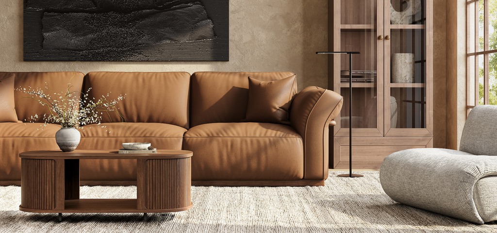 Warm modern living room with a brown leather sofa, wood coffee table, glass-front cabinet, and lounge chair.