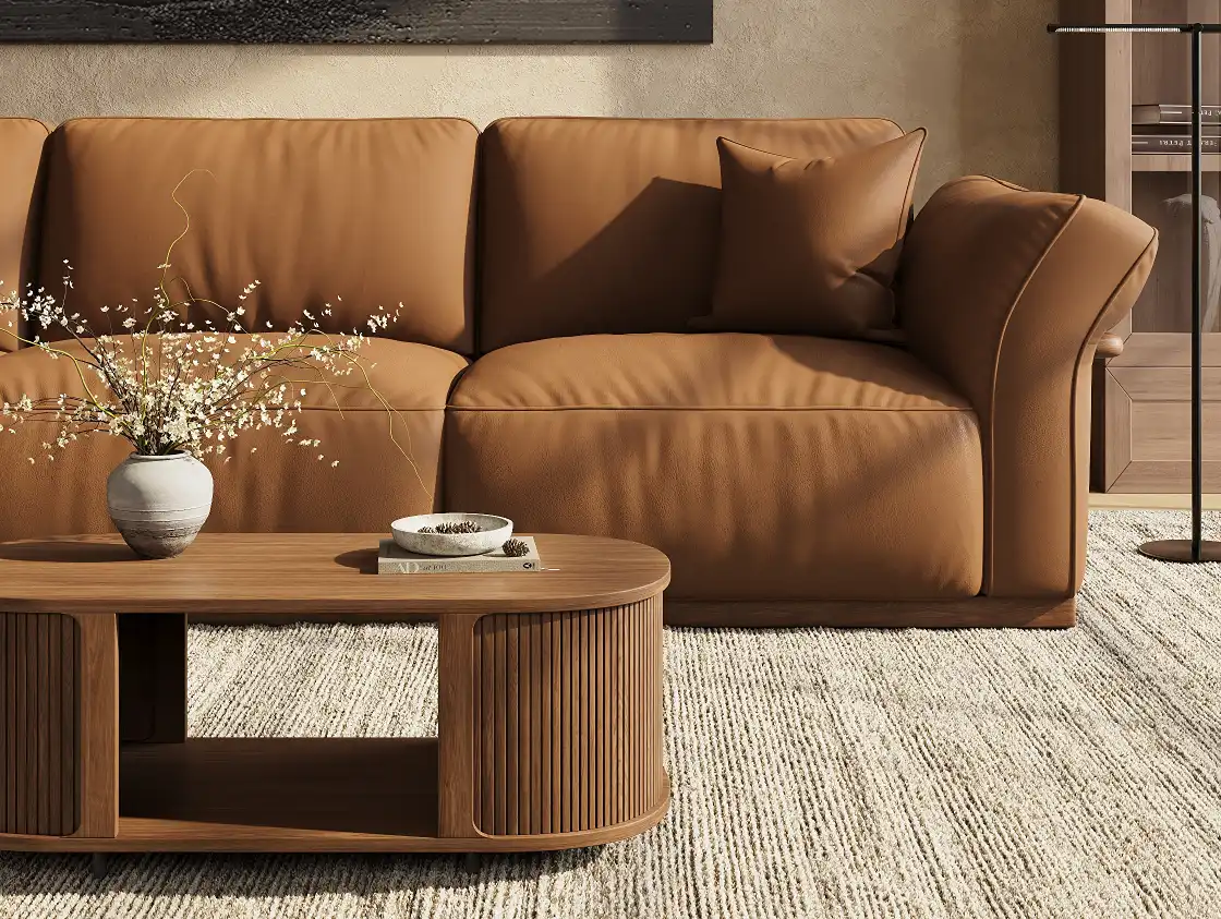 Soft brown leather sofa with plush cushions and relaxed, supple upholstery in a warm living room.
